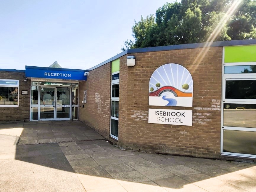 .Entrance to Isebrook School with reception sign and school logo.