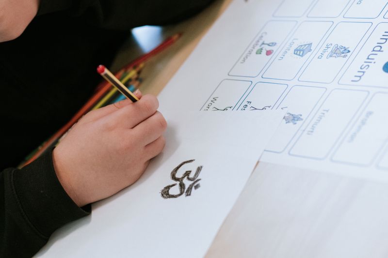 A student drawing an Om symbol
