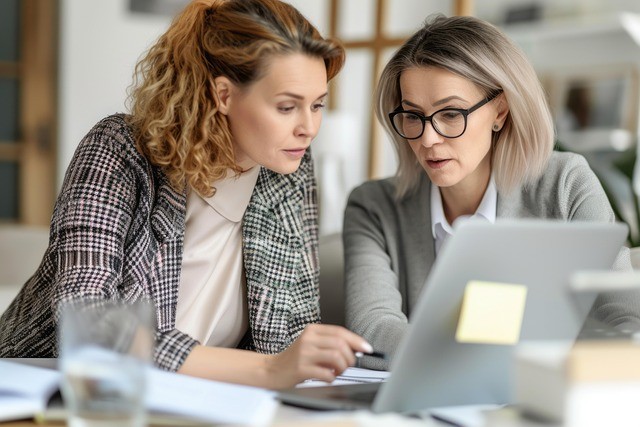 Two women in discussion looking at a laptop